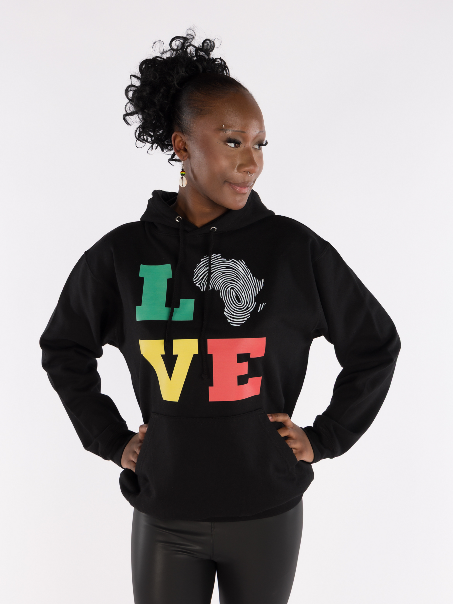 Woman wearing black unisex hoodie with LOVE text in red, gold, green and Africa map fingerprint design, Afrocentric streetwear.