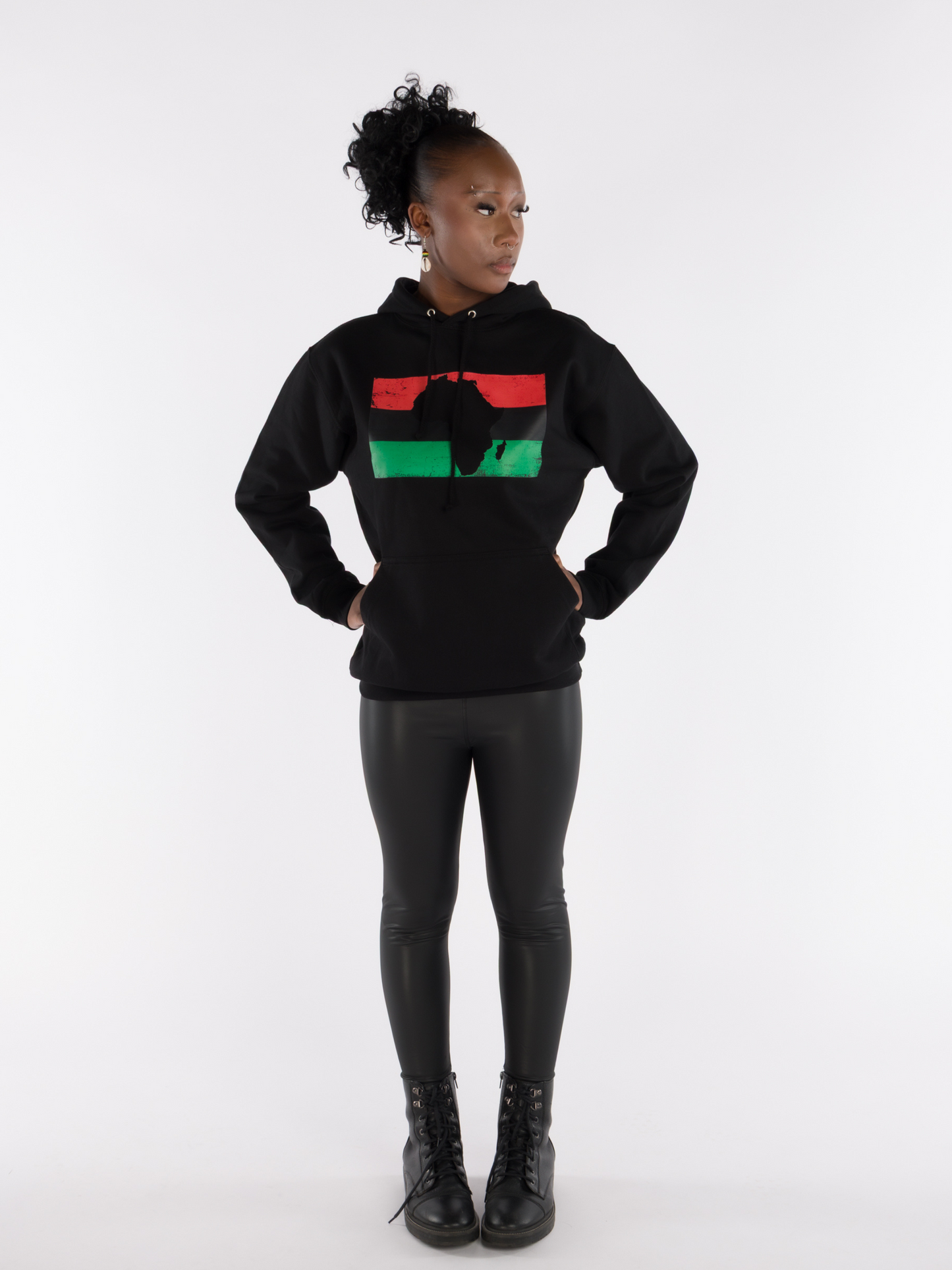 Full-body view of woman modeling unisex black hoodie with Pan-African flag and Africa map design, Afrocentric streetwear.